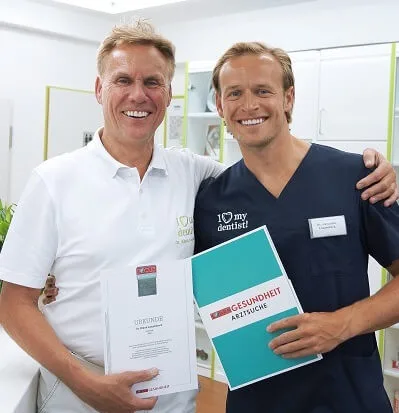 Die Zahnärzte Dr. Klaus und Alexander Langenbach halten die Auszeichnung von Focus in der Hand