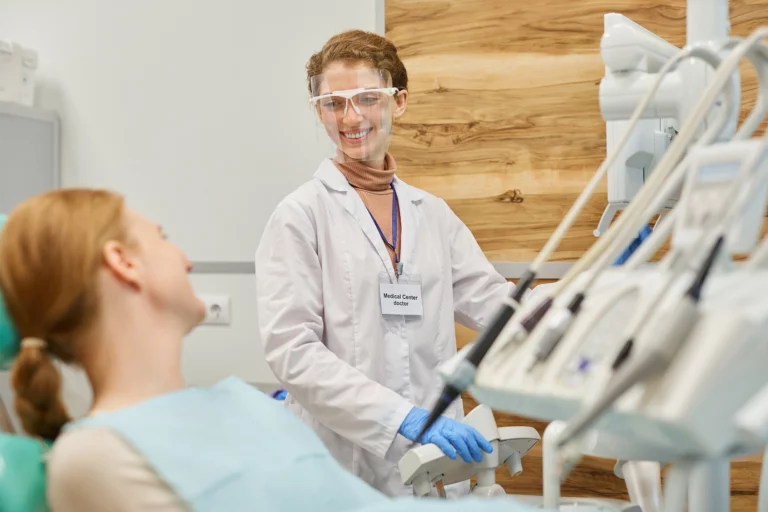 Eine Zahnärztin lächelt ihre Patientin an.